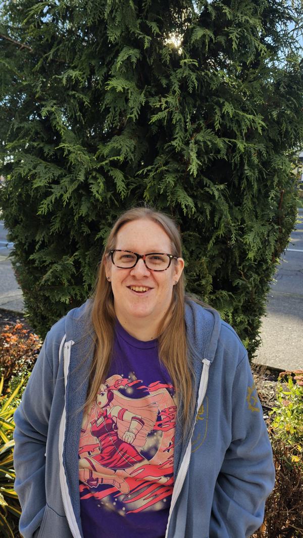 Emily Emerson smiling in front of greenery.